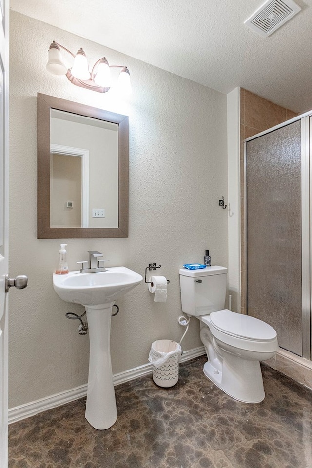 6921 Stonehenge Rd, Odessa, TX 79765 - bathroom with a shower stall, a textured ceiling, and stone finish floors