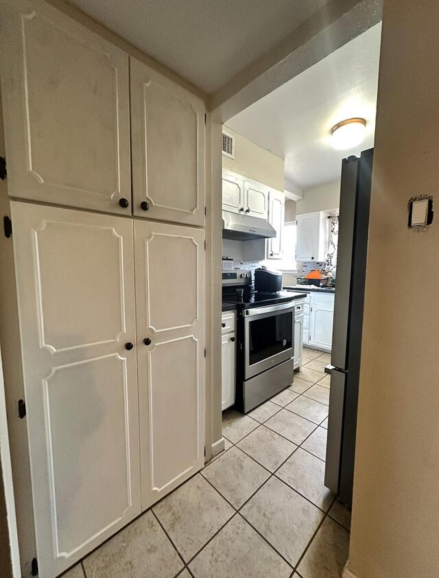 900 N Colpitts Ft, Stockton, TX 79735 - kitchen with stainless steel appliances, under cabinet range hood, dark countertops, and white cabinets
