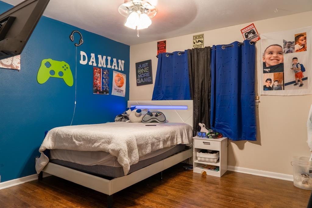bedroom featuring baseboards and wood finished floors