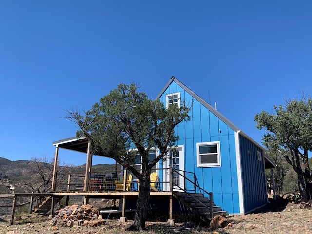 104 Low Meadow Pt, Fort Davis, TX 79734 - back of property with board and batten siding, a deck with mountain view, and stairway