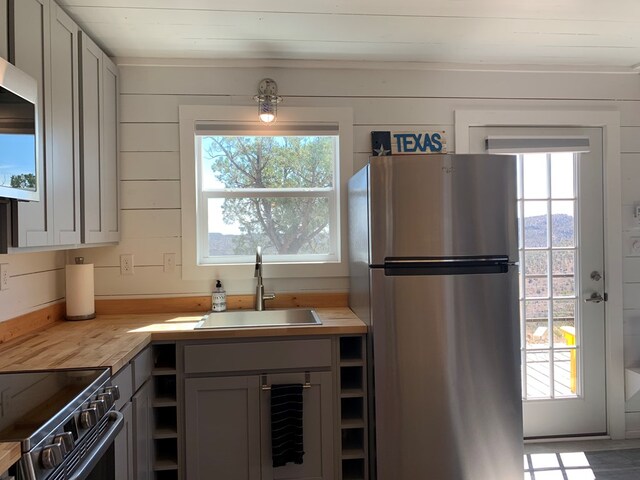 104 Low Meadow Pt, Fort Davis, TX 79734 - kitchen with open shelves, gray cabinets, a sink, wood counters, and stainless steel appliances