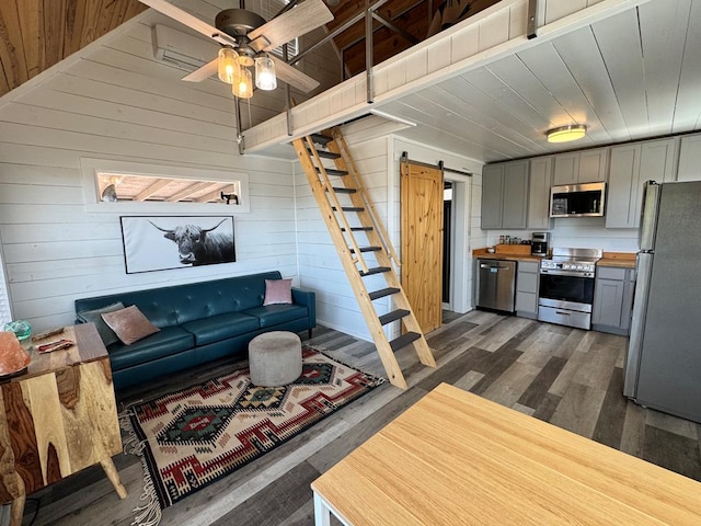 104 Low Meadow Pt, Fort Davis, TX 79734 - living area featuring a barn door, dark wood-style floors, and wood walls