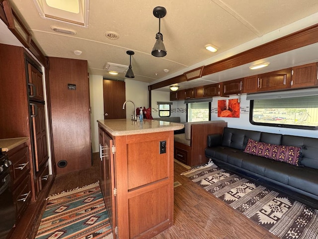 287 Fulcher Rd, Terlingua, TX 79852 - kitchen with dark wood-style floors, light countertops, pendant lighting, a kitchen island, and a kitchen breakfast bar