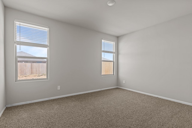 unfurnished room featuring baseboards and carpet