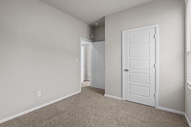 unfurnished bedroom with carpet floors, baseboards, and visible vents