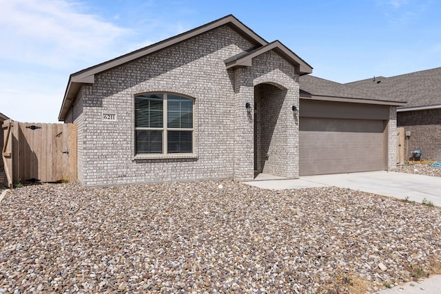 ranch-style home with a garage, fence, driveway, and brick siding