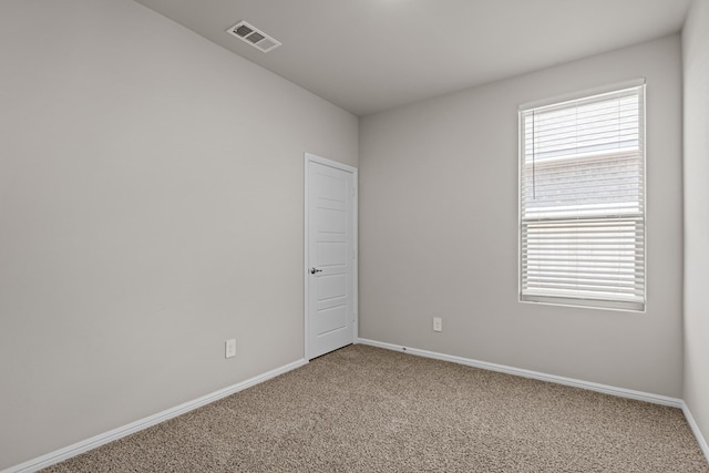 empty room featuring baseboards, carpet, and visible vents