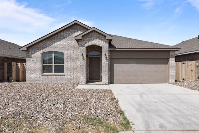 view of front of property with concrete driveway, brick siding, an attached garage, and fence