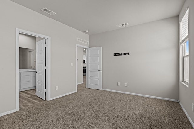 unfurnished bedroom featuring visible vents, baseboards, and carpet floors