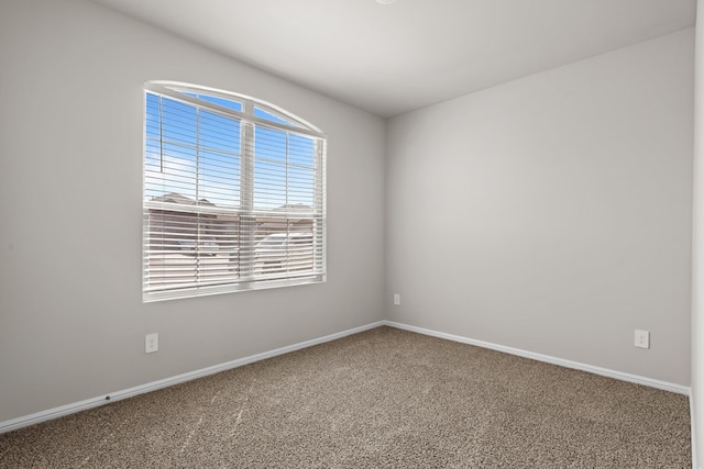 carpeted empty room featuring baseboards