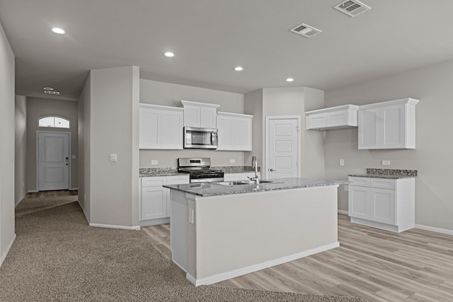 kitchen featuring stainless steel appliances, baseboards, visible vents, and a sink