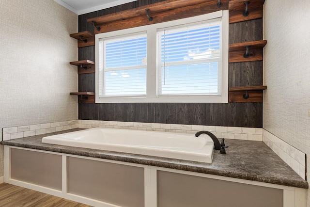 bathroom with a bathing tub, a wealth of natural light, and hardwood / wood-style flooring