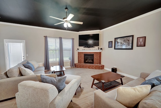 living area with ceiling fan, a brick fireplace, baseboards, and crown molding