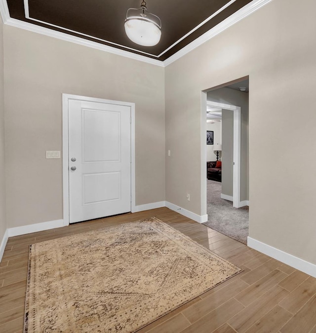 entrance foyer featuring crown molding, light wood finished floors, and baseboards