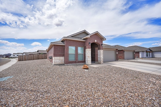 view of front facade with brick siding, fence, driveway, a garage, and a shingled roof