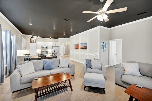 living area featuring ornamental molding, ceiling fan, light wood-style flooring, recessed lighting, and baseboards