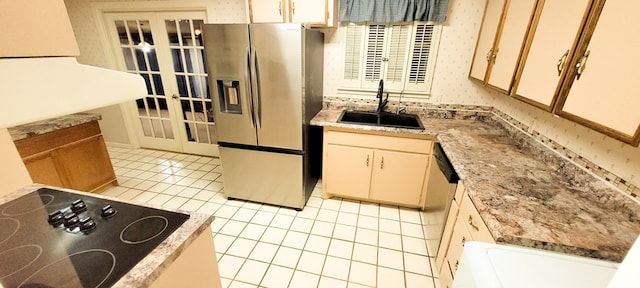 kitchen with sink, stainless steel refrigerator with ice dispenser, light stone countertops, black electric cooktop, and light tile patterned floors