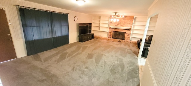 unfurnished living room with ceiling fan, carpet floors, and a fireplace