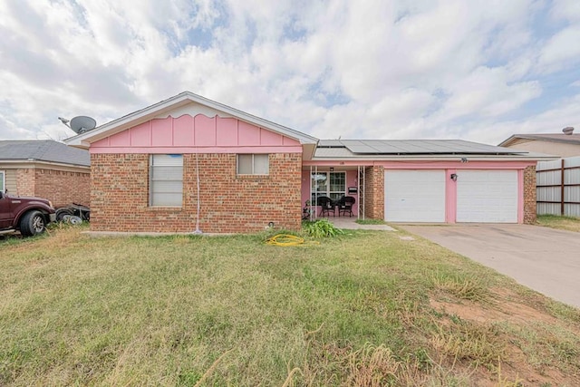 single story home with solar panels, a porch, a garage, and a front yard