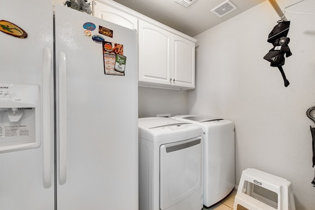 6920 Stonehenge Rd, Odessa, TX 79765 - clothes washing area with separate washer and dryer, cabinet space, and light tile patterned floors