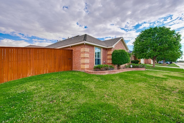 6920 Stonehenge Rd, Odessa, TX 79765 - view of side of property with brick siding, a yard, and a shingled roof