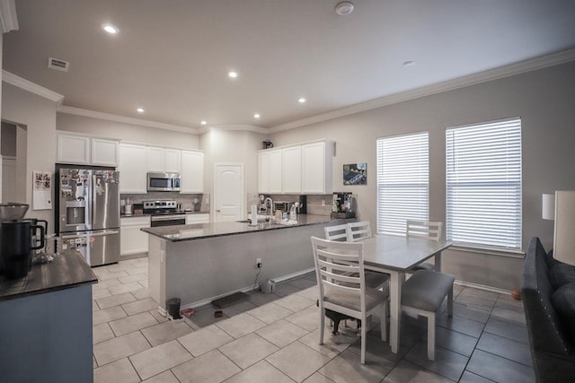 1322 E 89th St, Odessa, TX 79765 - kitchen featuring stainless steel appliances, tasteful backsplash, a sink, a peninsula, and white cabinets
