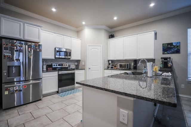 1322 E 89th St, Odessa, TX 79765 - kitchen featuring appliances with stainless steel finishes, a peninsula, backsplash, a sink, and dark stone countertops