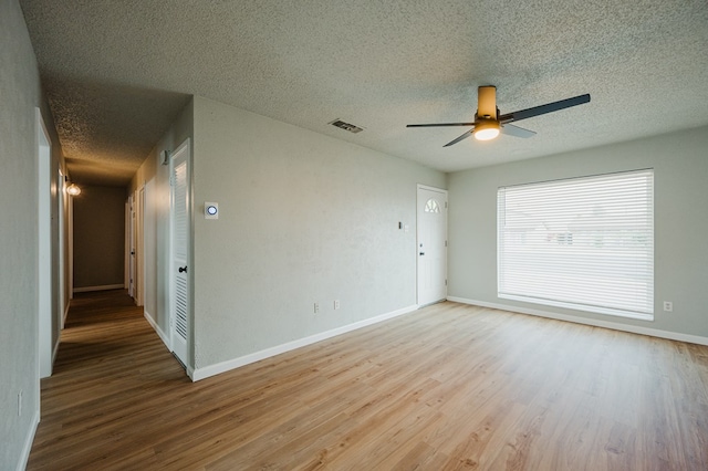 1613 E 52nd St, Odessa, TX 79762 - spare room featuring a textured ceiling, wood finished floors, ceiling fan, and baseboards