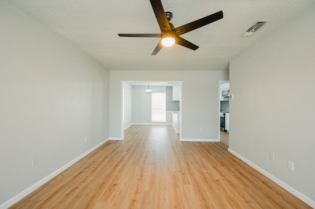 1613 E 52nd St, Odessa, TX 79762 - spare room with a textured ceiling, a ceiling fan, light wood-type flooring, a chandelier, and baseboards