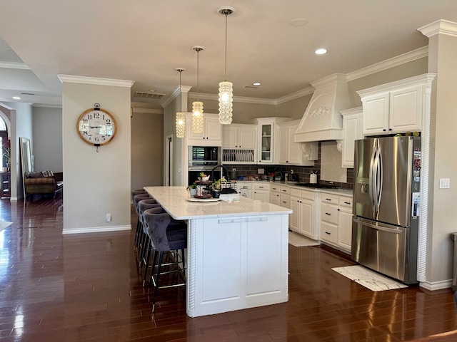 5 Muirfield Dr, Odessa, TX 79762 - kitchen with appliances with stainless steel finishes, premium range hood, dark wood-type flooring, a kitchen island, and ornamental molding
