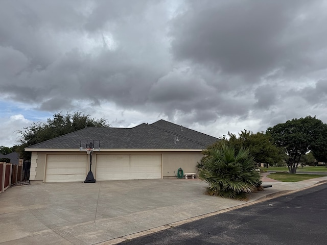 5 Muirfield Dr, Odessa, TX 79762 - view of side of property with stucco siding, concrete driveway, and a shingled roof