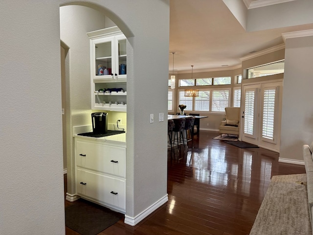 5 Muirfield Dr, Odessa, TX 79762 - corridor featuring crown molding, dark wood-style flooring, arched walkways, and a textured wall