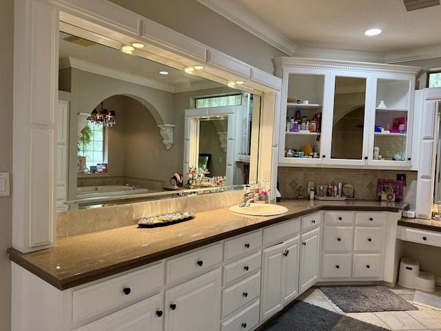 5 Muirfield Dr, Odessa, TX 79762 - full bathroom with crown molding, vanity, a chandelier, tasteful backsplash, and a garden tub