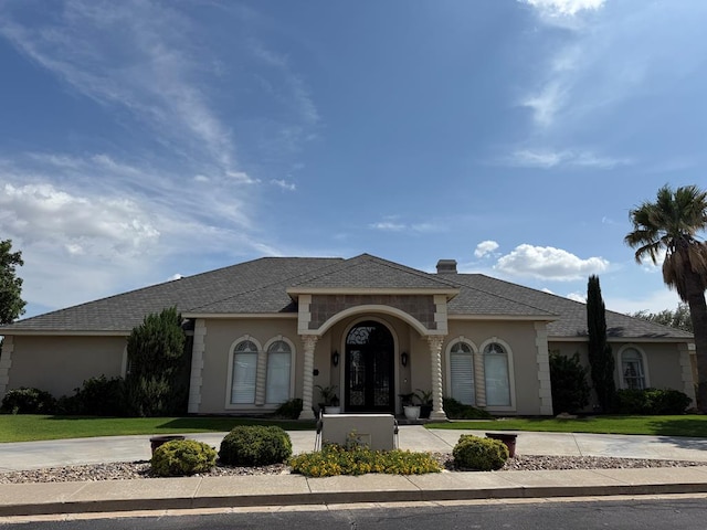 5 Muirfield Dr, Odessa, TX 79762 - view of front facade featuring french doors, a front lawn, curved driveway, and stucco siding