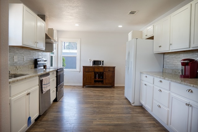 700 NE 2nd St, Andrews, TX 79714 - kitchen featuring appliances with stainless steel finishes, under cabinet range hood, decorative backsplash, white cabinetry, and recessed lighting