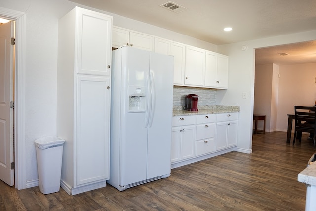 700 NE 2nd St, Andrews, TX 79714 - kitchen featuring white refrigerator with ice dispenser, dark wood-type flooring, white cabinetry, tasteful backsplash, and recessed lighting