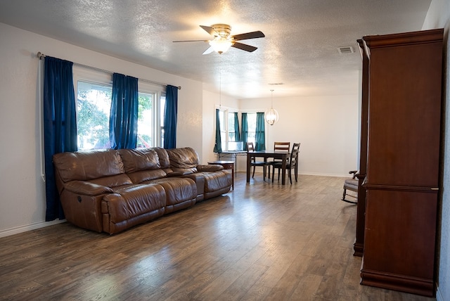 700 NE 2nd St, Andrews, TX 79714 - living area featuring a ceiling fan, a textured ceiling, and dark wood-style floors