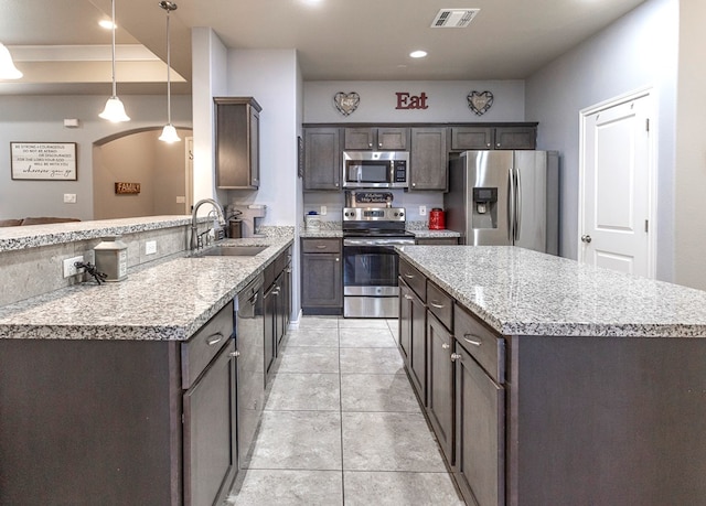 2004 Boise Dr, Odessa, TX 79762 - kitchen with stainless steel appliances, a sink, a center island, dark brown cabinetry, and recessed lighting