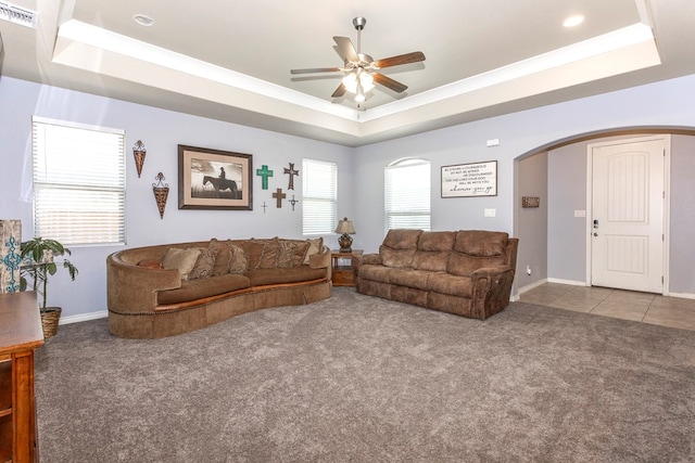 2004 Boise Dr, Odessa, TX 79762 - living area featuring a tray ceiling, arched walkways, carpet, ceiling fan, and baseboards
