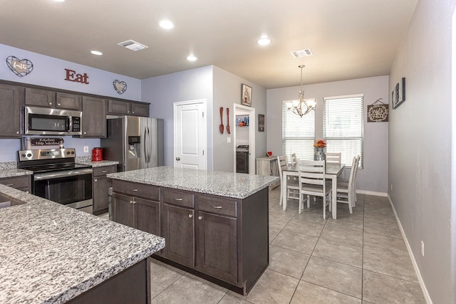 2004 Boise Dr, Odessa, TX 79762 - kitchen featuring appliances with stainless steel finishes, dark brown cabinetry, a chandelier, a center island, and recessed lighting