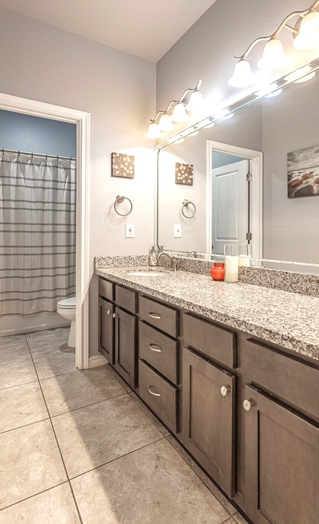 2004 Boise Dr, Odessa, TX 79762 - bathroom with vanity, toilet, tile patterned flooring, and a shower with curtain