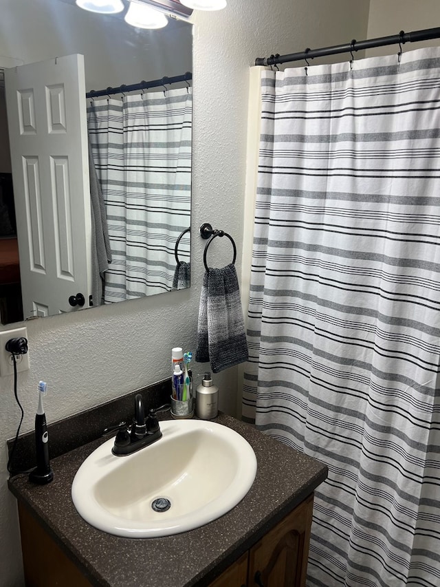 108 Horsehead, Crane, TX 79731 - full bath with a textured wall, vanity, and curtained shower