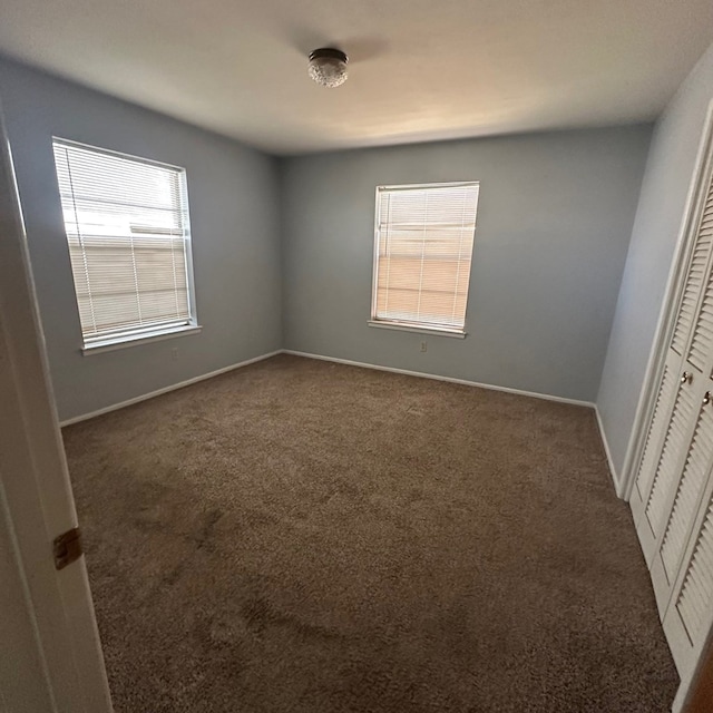 unfurnished bedroom with carpet, baseboards, and a closet
