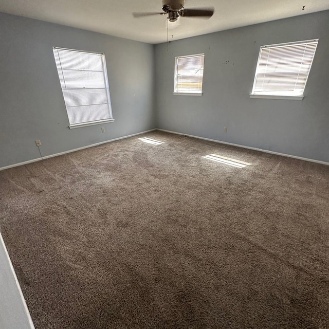 spare room with ceiling fan, carpet, and baseboards