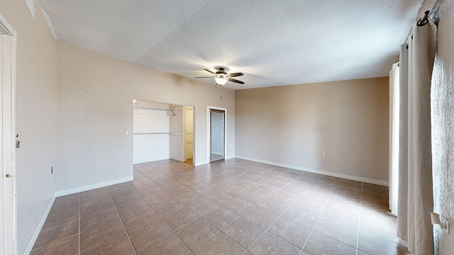 unfurnished bedroom featuring ceiling fan, light tile patterned floors, and a textured ceiling