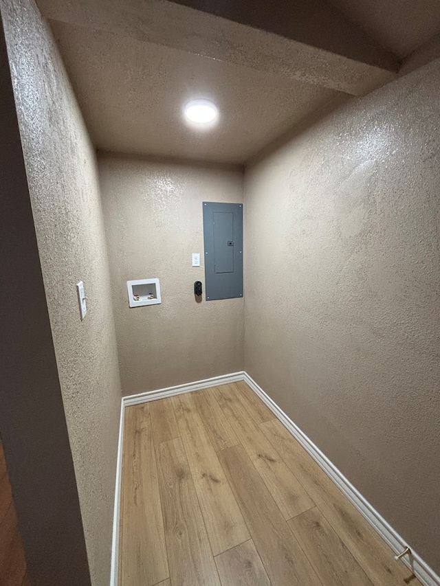 314 SW 11th Pl, Andrews, TX 79714 - laundry room with electric panel, hookup for a washing machine, wood finished floors, a textured wall, and baseboards