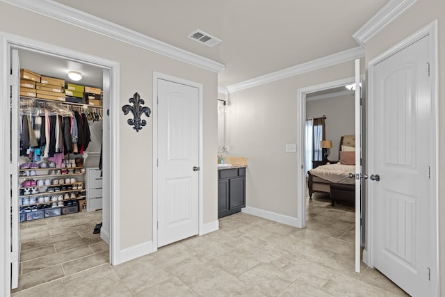 800 94th, Odessa, TX 79765 - bedroom with ornamental molding, a walk in closet, a closet, baseboards, and light tile patterned flooring
