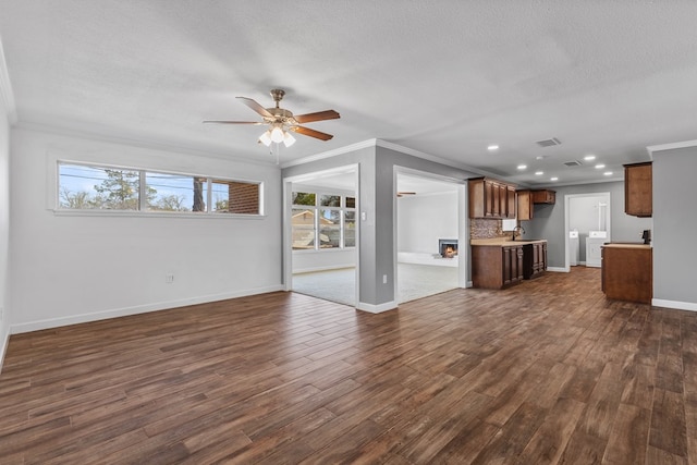 2616 E 21st St, Odessa, TX 79761 - unfurnished living room with ornamental molding, a ceiling fan, baseboards, dark wood-style floors, and recessed lighting