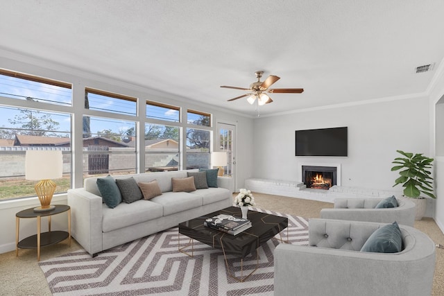 2616 E 21st St, Odessa, TX 79761 - living room featuring healthy amount of natural light, carpet floors, crown molding, a lit fireplace, and ceiling fan