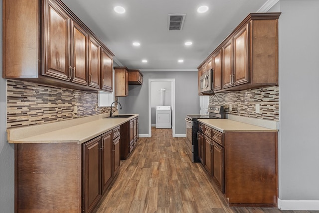 2616 E 21st St, Odessa, TX 79761 - kitchen featuring appliances with stainless steel finishes, a sink, washer / dryer, baseboards, and recessed lighting